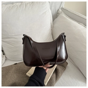 Nahaufnahme einer dunkelbraunen Hobo-Tasche aus glänzendem Lackleder mit Text