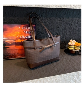 Detail of dark brown herringbone fabric and leather tote bag with metallic buckle