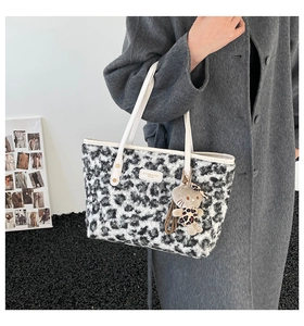 Detail view of winter leopard print tote bag with plush texture and cute cat pendant