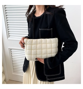 Detail der cremeweißen gesteppten Clutch mit flauschigem Stoff und goldenem Reißverschluss
