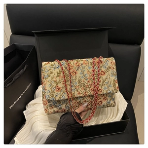Detailansicht der Blumen-Brokat-Stickerei der Klappentasche in einer Geschenkbox