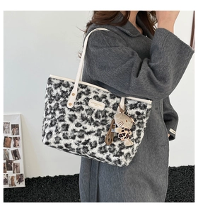Detail of leopard print faux fur tote bag with white leather straps and cat charm