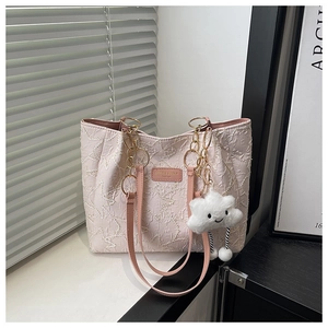 Détail d'un sac cabas rose matelassé avec motifs d'étoiles et charm nuage doux