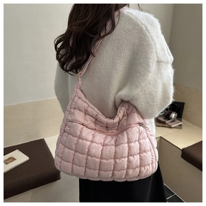 Sac bandoulière rose matelassé avec texture rembourrée et poches latérales, scène de vie