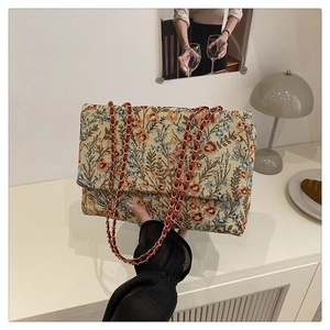 Detaillierte Stickerei mit orangefarbenen und blauen Blumen auf Jacquard-Tasche