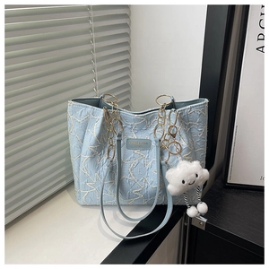 Détail du sac cabas bleu clair matelassé avec broderie étoile et pendentif nuage
