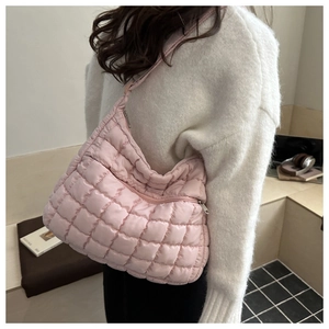 Gros plan du sac nuage matelassé rose montrant la texture bouffante et le porté épaule