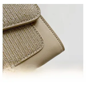 Close-up of beige leather handbag with glittery tweed texture and fine stitching