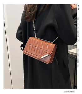 Brown quilted crossbody bag with gold chain strap shown on model for size and style