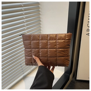 Détail d'une pochette matelassée marron foncé avec rembourrage doux et motif carré