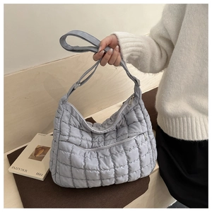 Vue détaillée du sac cabas matelassé bleu clair avec poche frontale zippée pratique