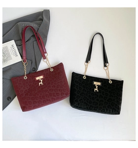 Dettaglio di borse tote leopardate bordeaux e nere con catena dorata e pendente a cervo