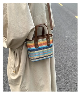 Detail of a colorful striped woven tote bag with leather handles and metallic rivets