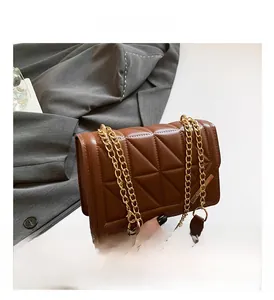 Detail of brown quilted faux leather bag with gold chain strap and magnetic closure