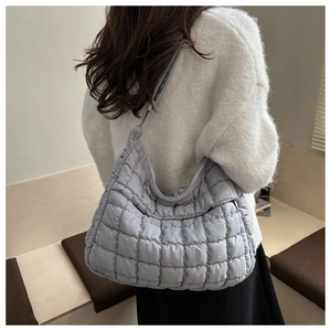 Détail du sac à bandoulière matelassé gris clair avec un effet nuage moelleux