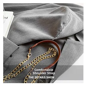 Detail of premium golden metal chain and brown leather shoulder strap with neat stitching