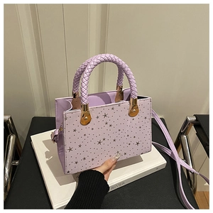 Close-up of light purple handbag with star rivets and woven handle detail
