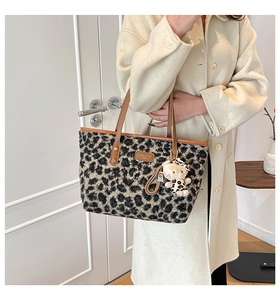 Detailed plush leopard print tote bag with brown leather straps and character charm