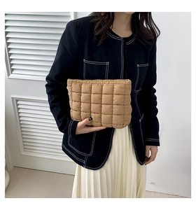 Detail der kamelfarbenen gesteppten Puffer-Clutch mit quadratischer Polsterung und Textur