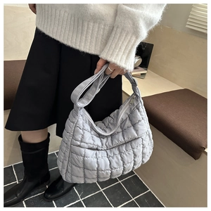 Détail macro d'un grand sac cabas matelassé gris clair avec fermeture éclair en métal