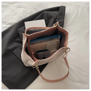 Vue détaillée de l'intérieur spacieux d'un sac cabas en tweed blanc avec accessoires