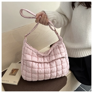 Détail du sac bandoulière matelassé rose montrant la texture rembourrée et les coutures