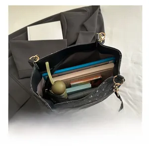 Detail showing high capacity interior of black star and moon tote bag with daily items