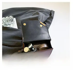 Top view of brown leather bag interior showing capacity for phone and cosmetics