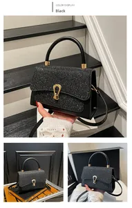 Close-up of black sequined handbag featuring golden horseshoe buckle and curved top handle