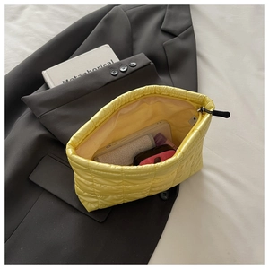 Vue de dessus d'un sac à main matelassé jaune montrant sa capacité de rangement