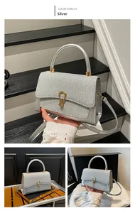 Detail of silver rhinestone handbag with gold horseshoe buckle and adjustable shoulder strap