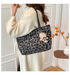 Side view of leopard print plush tote bag with black straps and kitty charm
