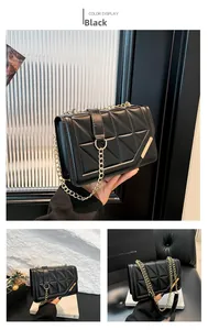 Detail of black quilted leather shoulder bag with gold chain strap and elegant hardware