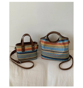 Detail of colorful woven handbags with brown leather straps and gold-tone hardware
