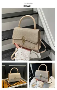 Detailed view of khaki handbag featuring sequined flap and golden horseshoe lock