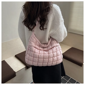 Vue de dos du modèle portant un grand sac cabas rose matelassé avec une texture moelleuse