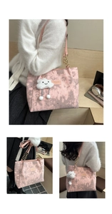 Detail of pink tie-dye tote bag with star patterns, metal chain strap and cloud charm