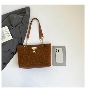 Dettaglio della borsa tote leopardata con ciondolo dorato e iPad per riferimento di misura