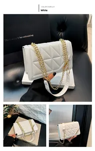Detailed view of white quilted crossbody bag with gold chain and metal trim accents