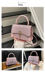 Detail of pink glitter handbag with golden hardware and horseshoe-shaped buckle decoration