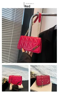 Close-up of red quilted leather bag with geometric stitching and gold chain strap