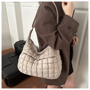 Détail du sac hobo matelassé beige avec texture nuage et bandoulière ajustable