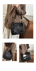 Detail of black star and moon pattern tote bag with gold chain strap and cloud charm