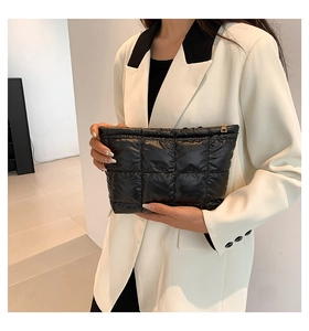 Détail de la pochette matelassée noire avec coutures carrées et fermeture éclair