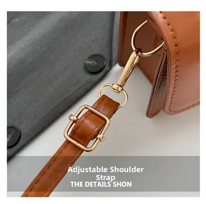 Detail of adjustable caramel leather shoulder strap with polished gold-tone buckle hardware