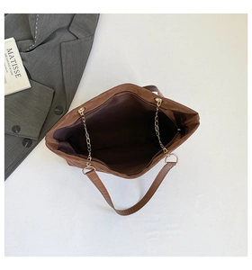 Vista dettagliata della borsa tote marrone scuro con cerniera e tracolla a catena dorata