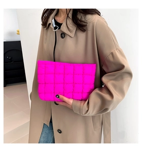 Detail der leuchtend rosa gesteppten Clutch mit quadratischer Polsterung und Textur