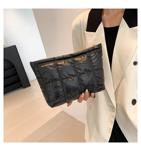 Gros plan sur une pochette matelassée noire en nylon avec fermeture éclair dorée chic