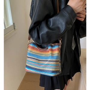 Colorful woven tote bag with brown leather handles and adjustable crossbody strap