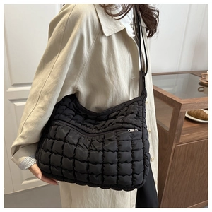 Détail du sac nuage noir matelassé avec texture bouffante et poche zippée en métal